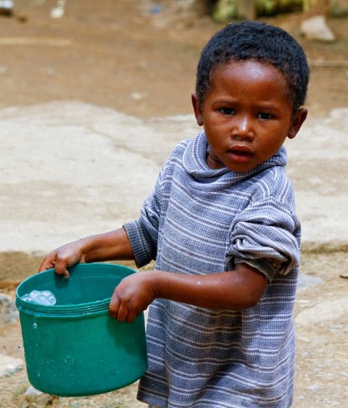 enfant qui porte de l'eau